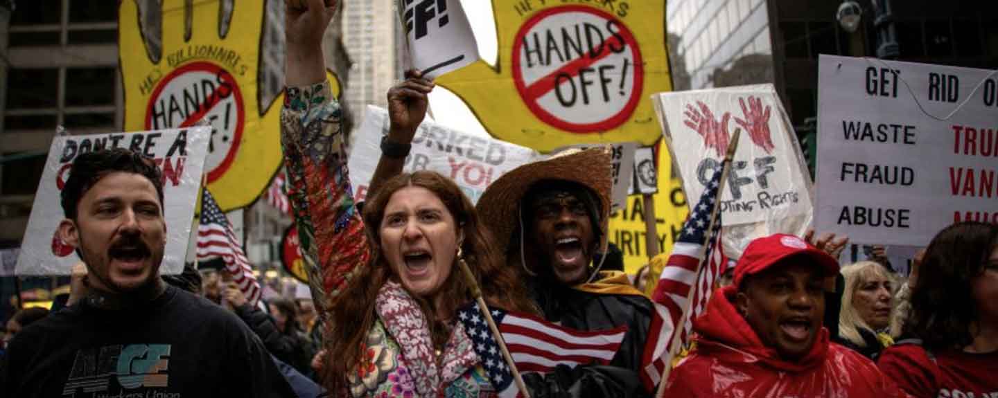 People with signs protesting Trump, Musk and Vance.